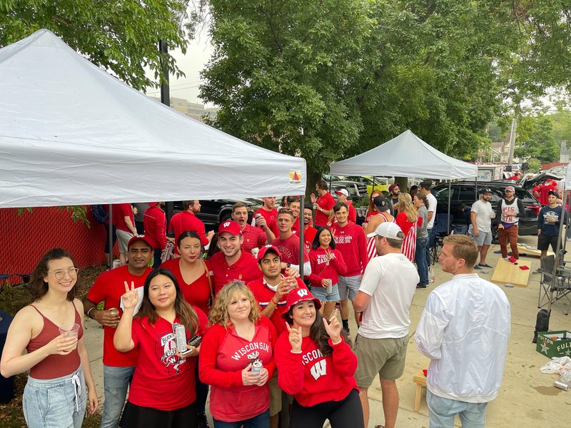 Group of Wisconsin Badgers fans throwing up the W, ready to head into the game.