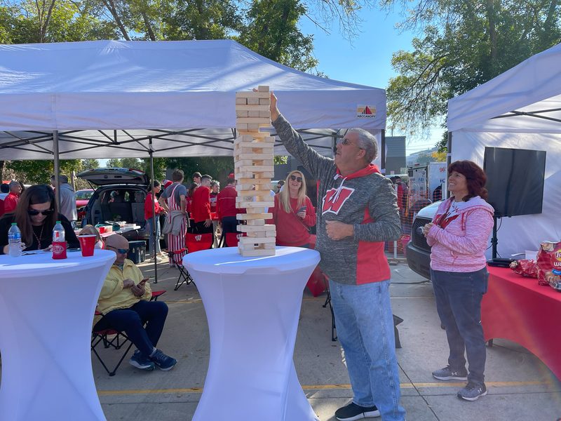 Badgers fan playing giant Jenga at a GameDay Your Way tailgate in Madison, Wisconsin.