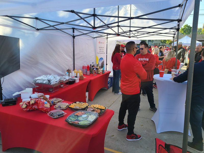 Catering spread with chafing dishes and fresh trays at a GameDay Your Way Badgers tailgate in Madison.