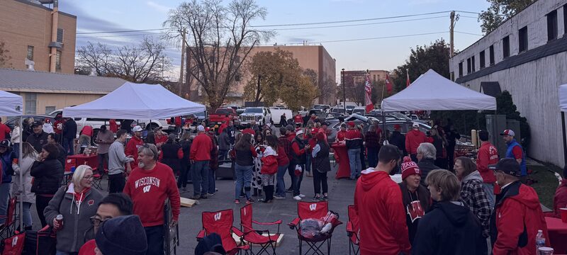 Wide view of the Regent Street Fan Fest crowd and tents at dusk near Camp Randall in Madison.